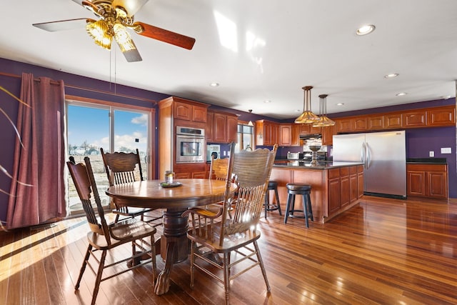 dining area with ceiling fan and dark hardwood / wood-style floors