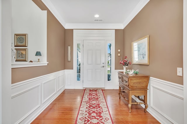 entryway featuring light hardwood / wood-style floors and crown molding