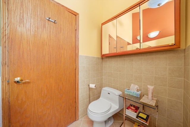 bathroom with tile walls, toilet, and tile patterned floors