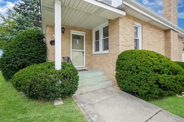 view of exterior entry featuring a lawn