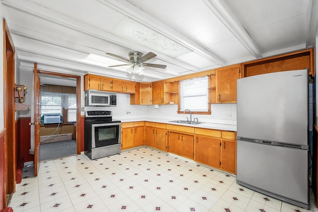 kitchen featuring appliances with stainless steel finishes, backsplash, beam ceiling, ceiling fan, and sink