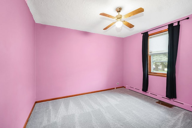 carpeted spare room with a baseboard heating unit, ceiling fan, and a textured ceiling