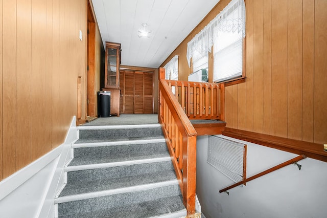 stairway with wood walls and carpet