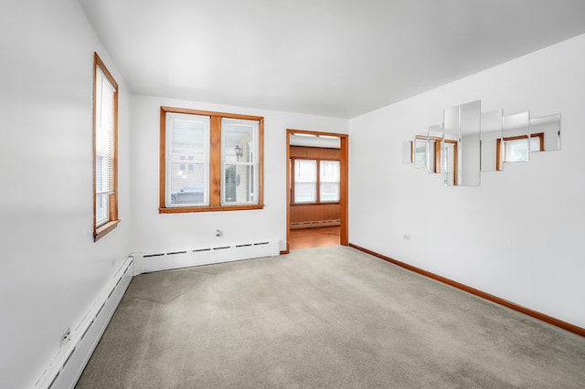 spare room featuring light carpet and a baseboard radiator