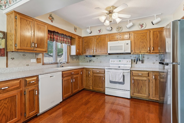 kitchen with ceiling fan, sink, white appliances, track lighting, and dark hardwood / wood-style floors