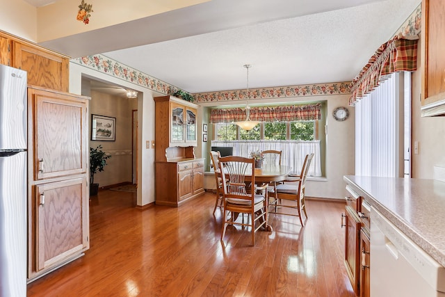 dining room with a textured ceiling and light hardwood / wood-style floors