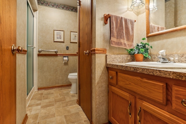 bathroom featuring vanity, toilet, and a shower with door