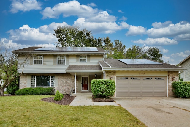 view of front of home featuring a front yard, a garage, and solar panels