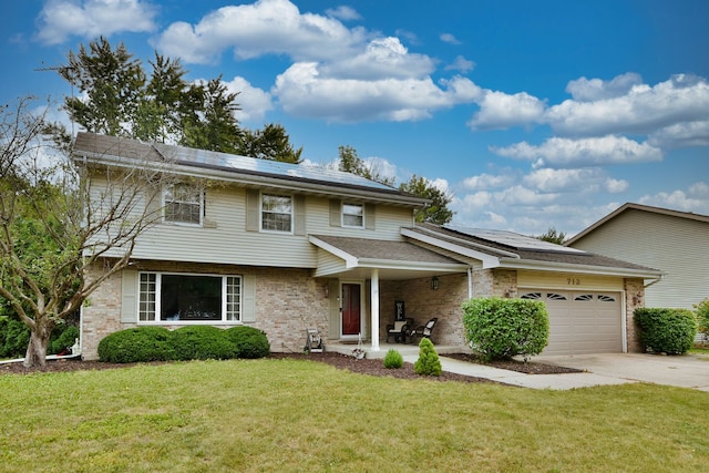 view of front of house with a garage, solar panels, and a front yard