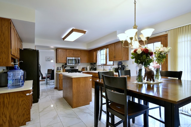 kitchen featuring pendant lighting, a notable chandelier, stainless steel appliances, and a center island