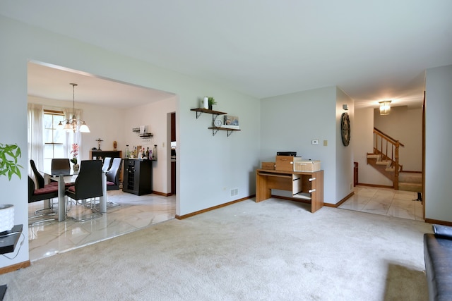 unfurnished living room featuring an inviting chandelier and light carpet