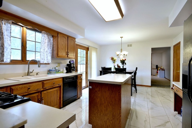 kitchen featuring black dishwasher, decorative light fixtures, sink, and a center island