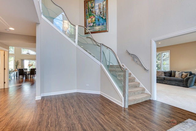 stairway featuring hardwood / wood-style flooring and a high ceiling