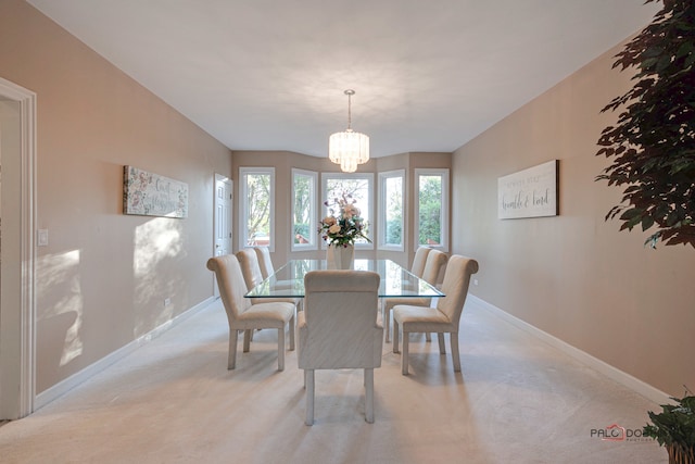 carpeted dining room featuring an inviting chandelier