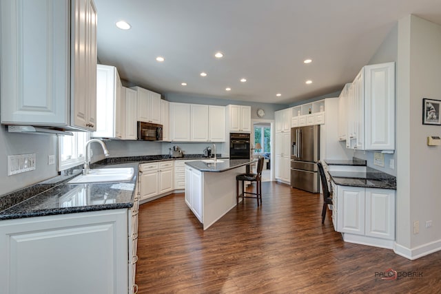 kitchen featuring dark wood-type flooring, a kitchen island with sink, sink, white cabinets, and appliances with stainless steel finishes