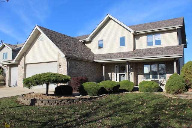 view of front of property featuring a front lawn, covered porch, and a garage