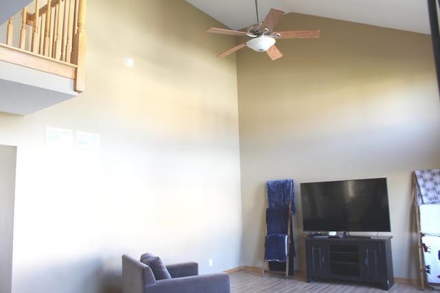 living room featuring hardwood / wood-style floors, high vaulted ceiling, and ceiling fan