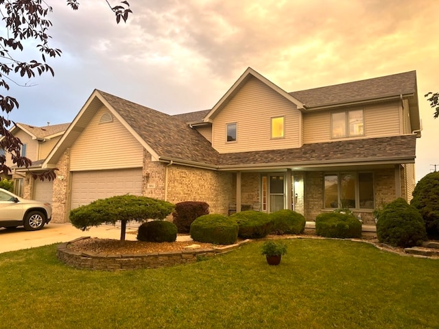 view of front of property featuring a yard, covered porch, and a garage