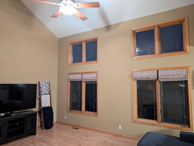 living room with ceiling fan, lofted ceiling, and light wood-type flooring