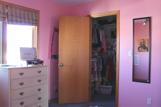 unfurnished bedroom featuring a closet and dark colored carpet