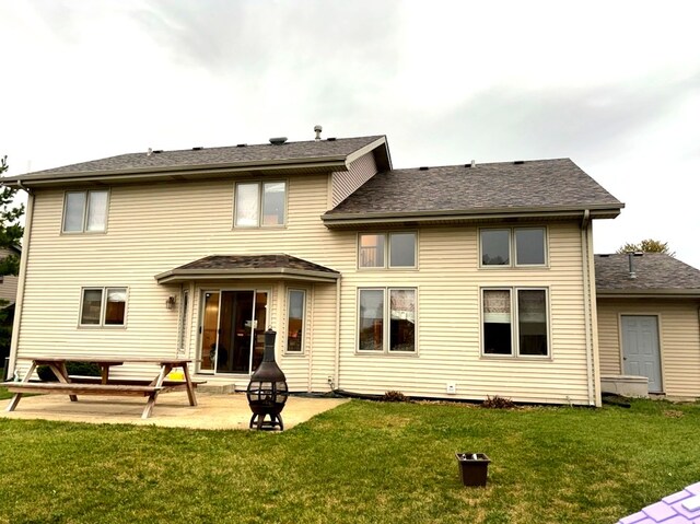 back of house with a yard and a patio