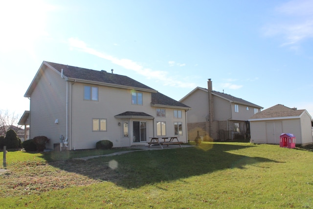 back of property with a patio area and a lawn