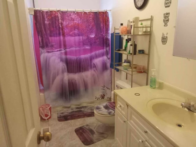 bathroom with tile patterned floors, curtained shower, vanity, and toilet