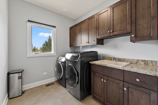 washroom with cabinets, light tile patterned flooring, sink, and separate washer and dryer