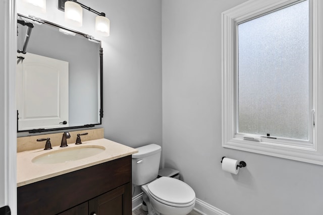 bathroom featuring vanity, toilet, and a wealth of natural light