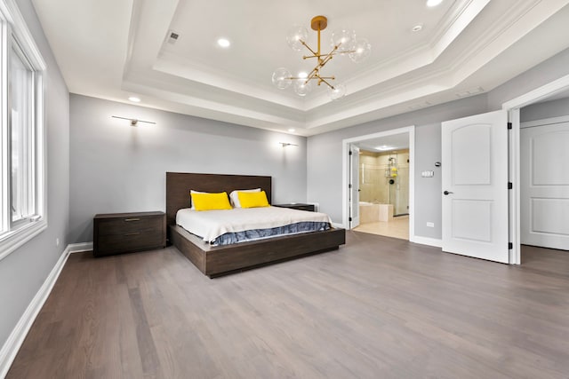 bedroom with hardwood / wood-style floors, a raised ceiling, an inviting chandelier, crown molding, and ensuite bath