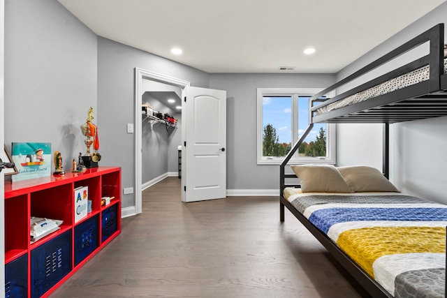 bedroom featuring dark wood-type flooring, a closet, and a walk in closet