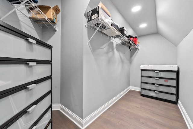 walk in closet with hardwood / wood-style floors and vaulted ceiling