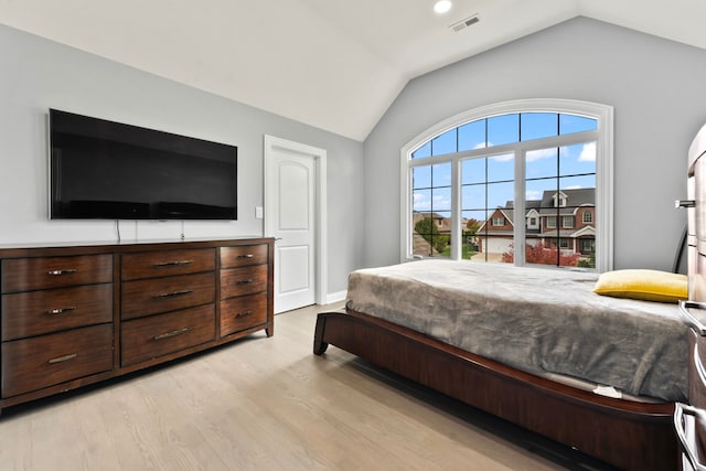 bedroom with vaulted ceiling and light wood-type flooring