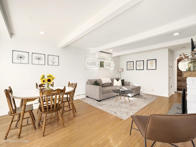 living room with an AC wall unit, beamed ceiling, and light wood-type flooring