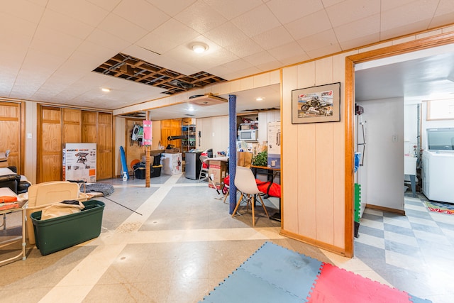 basement with wooden walls and washer / dryer