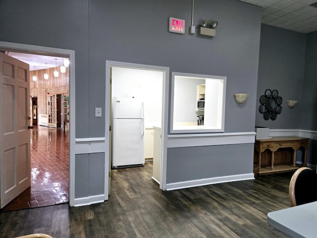 corridor featuring dark hardwood / wood-style floors and a high ceiling