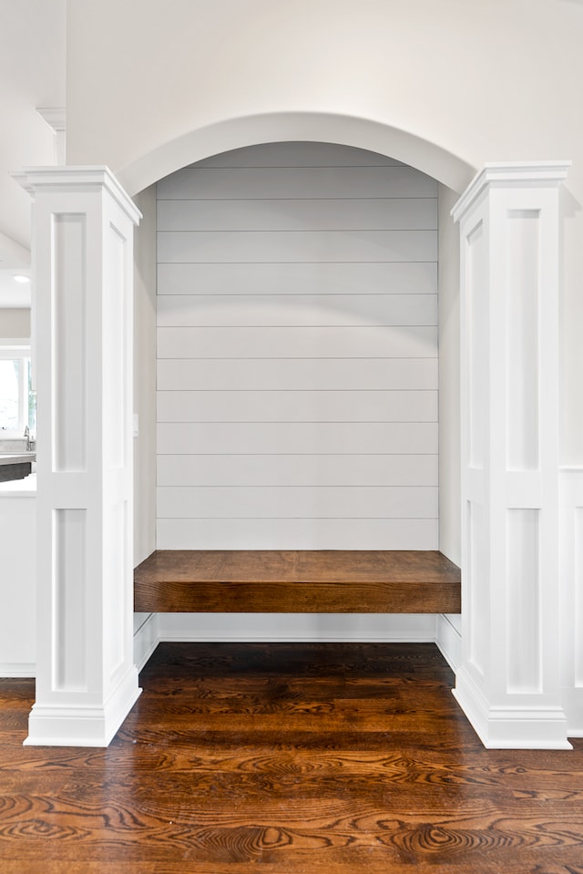 mudroom featuring dark wood-type flooring and ornate columns