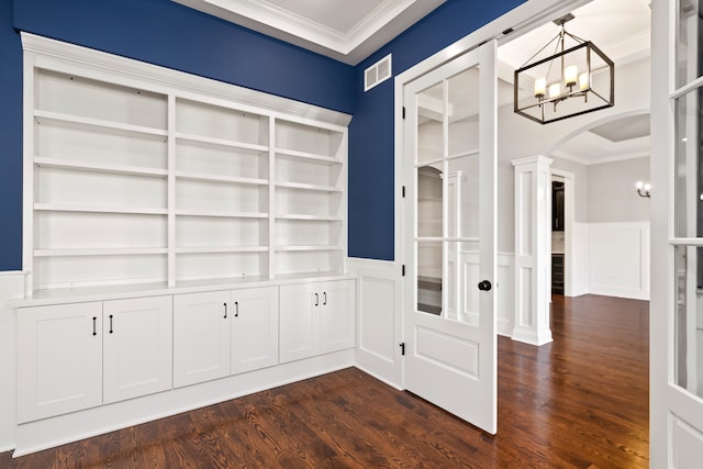 interior space with crown molding, decorative columns, dark hardwood / wood-style flooring, and built in shelves