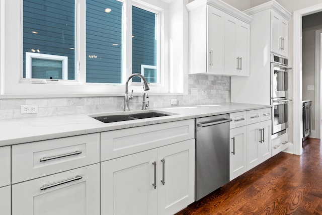 kitchen featuring white cabinetry, backsplash, stainless steel appliances, dark hardwood / wood-style floors, and sink