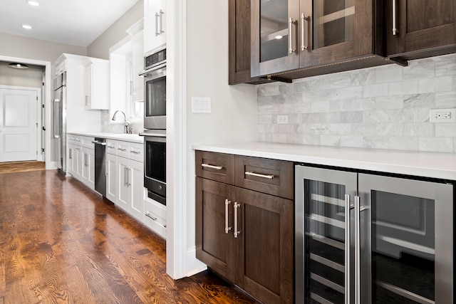 kitchen with beverage cooler, white cabinets, dark hardwood / wood-style floors, and dark brown cabinetry