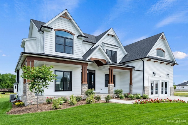 view of front of home with a front yard and central AC unit