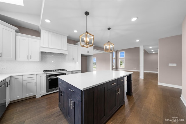 kitchen featuring pendant lighting, white cabinets, a kitchen island, stainless steel appliances, and dark hardwood / wood-style flooring