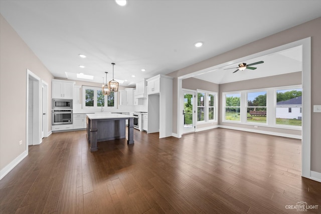 kitchen featuring a wealth of natural light, stainless steel appliances, a kitchen bar, and a kitchen island