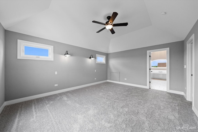 unfurnished bedroom with carpet, ceiling fan, vaulted ceiling, and ensuite bath