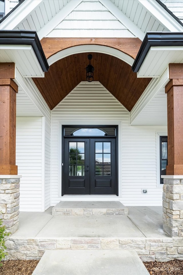 entrance to property with a porch and french doors