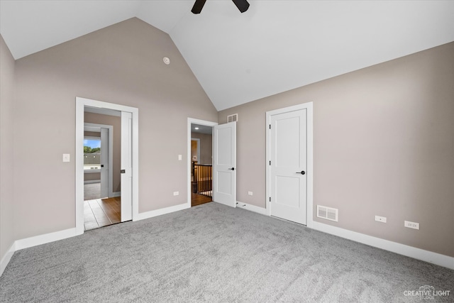 unfurnished bedroom featuring carpet, ceiling fan, and high vaulted ceiling