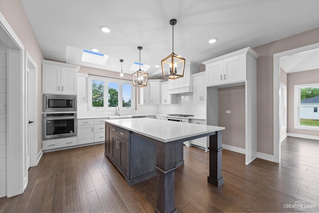 kitchen with white cabinetry, a center island, stainless steel appliances, and plenty of natural light