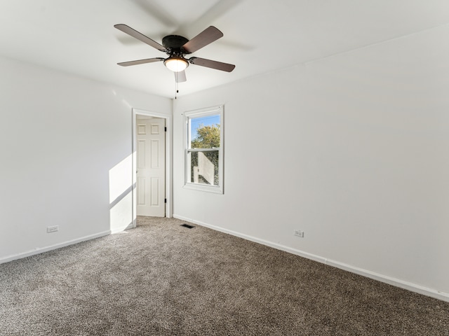 carpeted spare room featuring ceiling fan