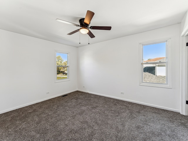 empty room featuring dark colored carpet and ceiling fan