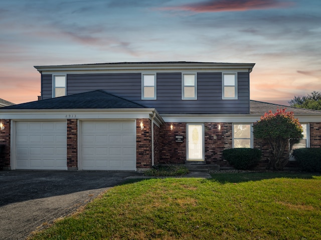 front facade featuring a yard and a garage